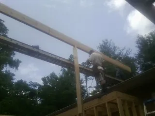 Carpenter setting a ridge beam over a new addition frame — Ice Dam Removal by Roofing Brothers in Basking Ridge