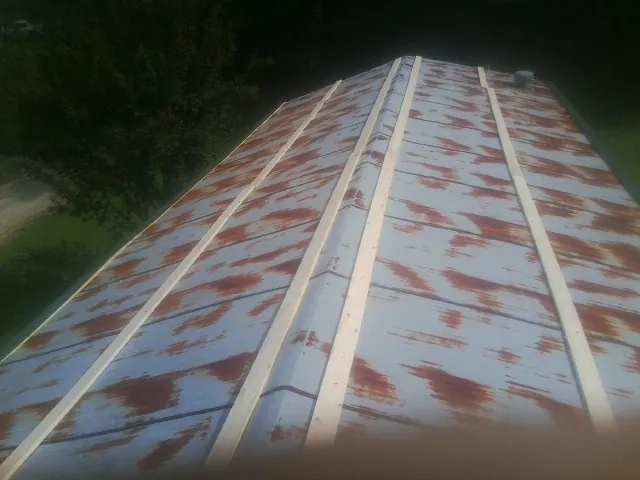 Rusted metal roof panels with new wood purlins before replacement — Storm Damage Roof Repair in Basking Ridge by Roofing Brothers