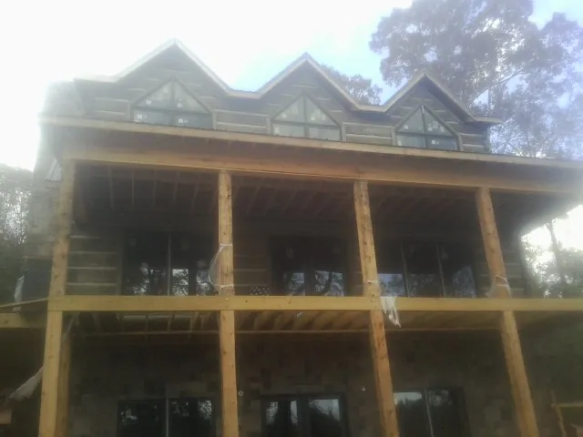 Dormers and porch framing on a large log home under construction — Roof Coating work by our crew in Basking Ridge