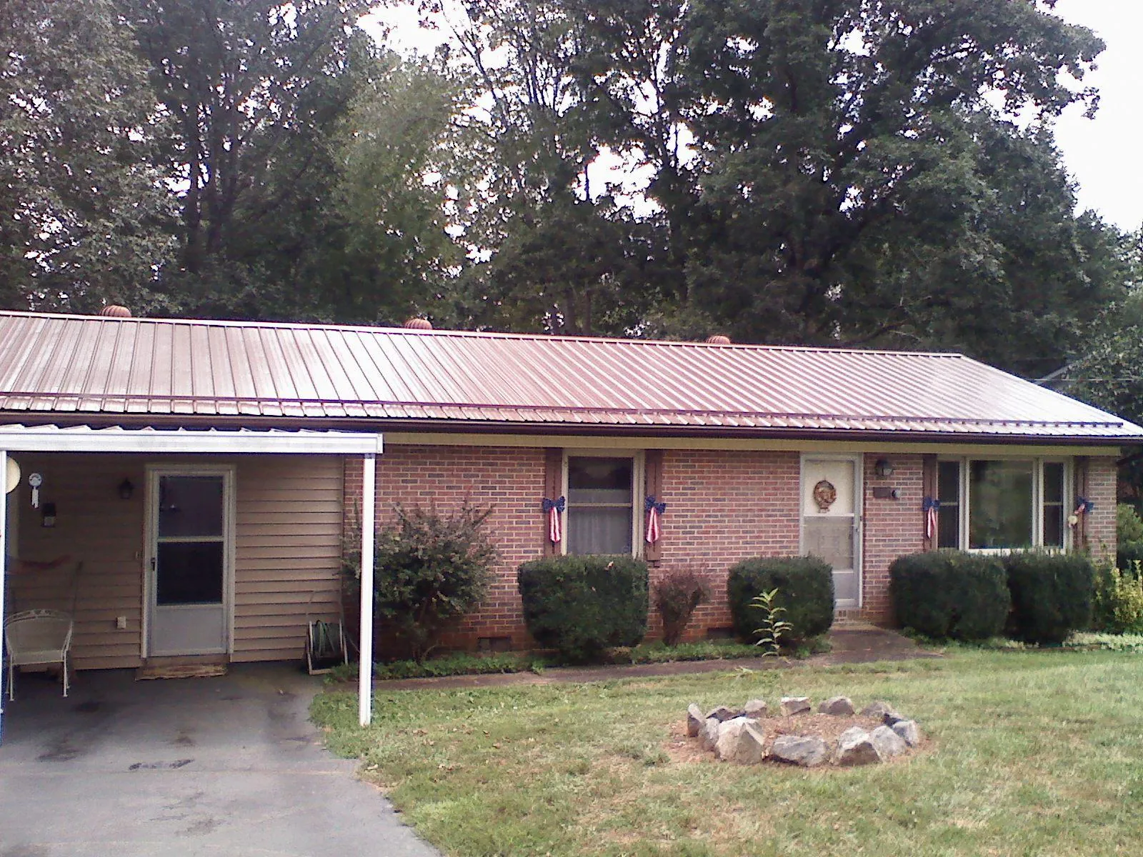 Bronze metal roof and carport on a brick ranch home — Roof Repair work by our crew in Basking Ridge